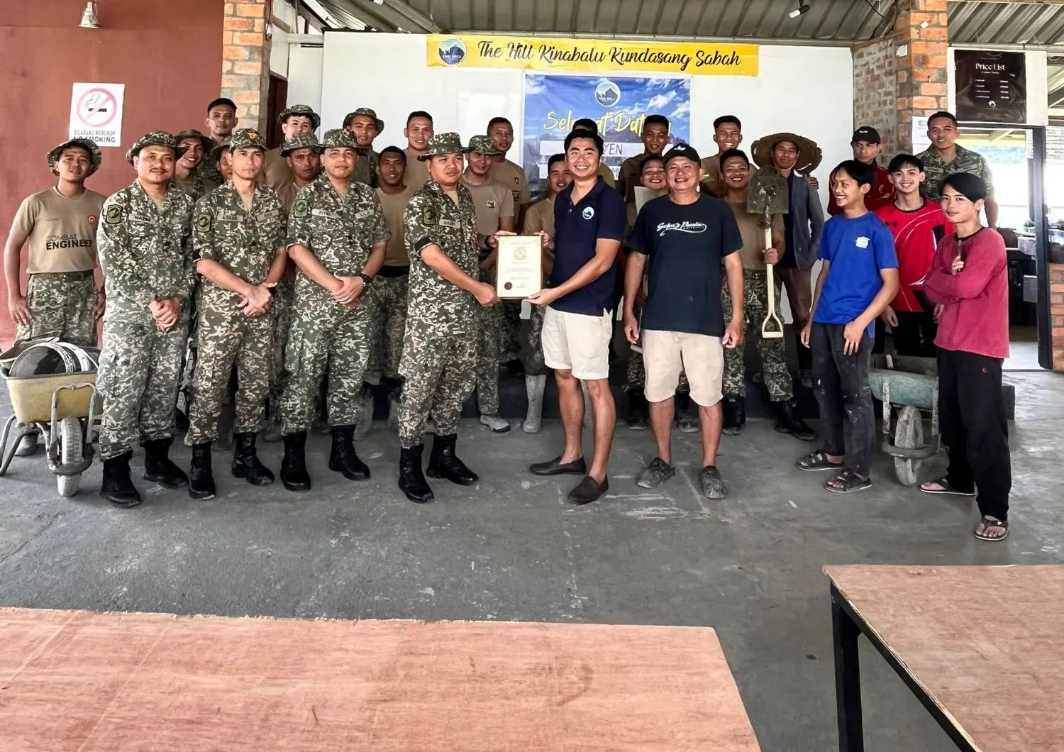An Army unit and The Hill Kinabalu team in the hall under a welcome banner